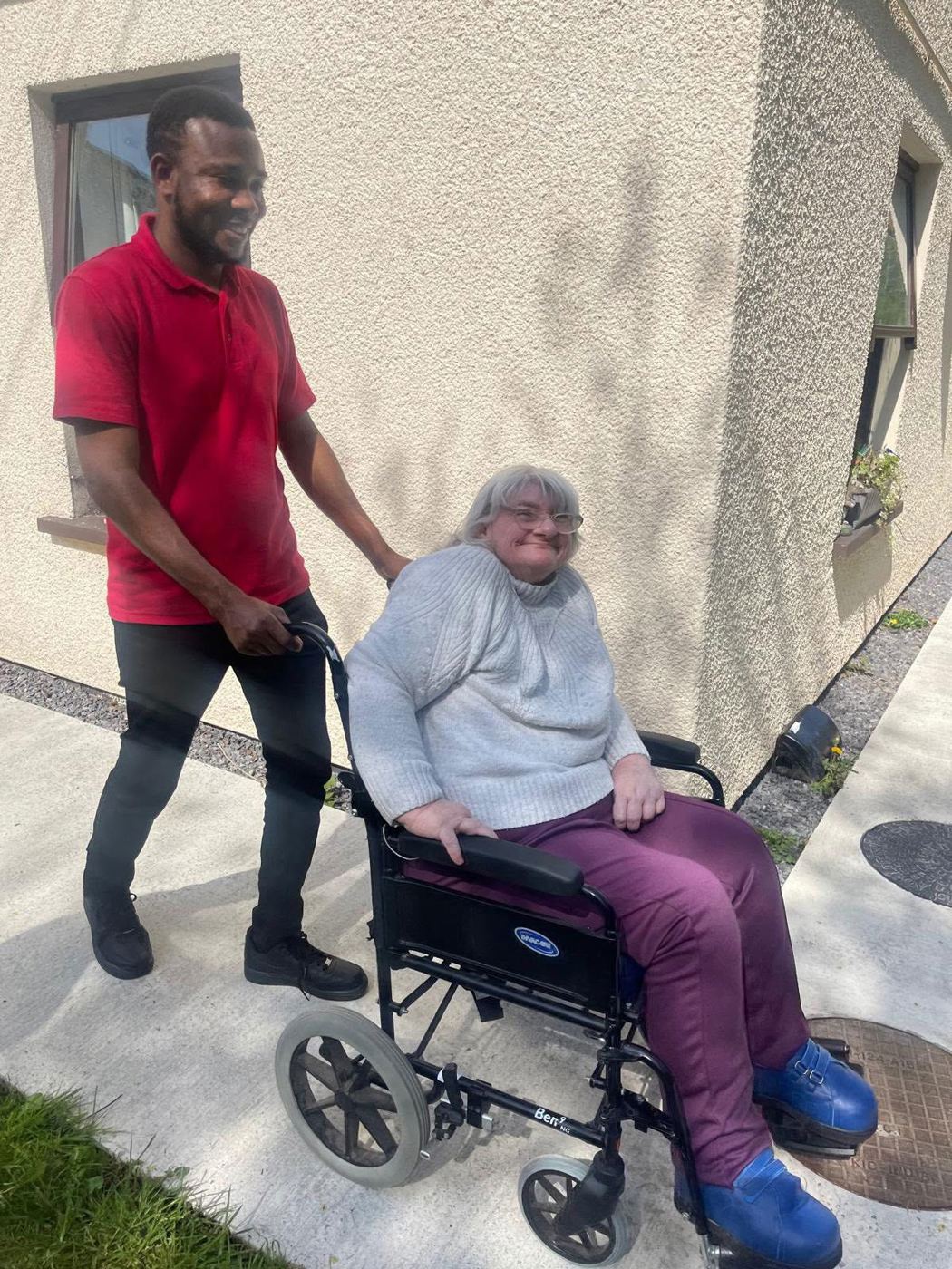 A carer supporting a resident in the grounds at Rickeston Mill